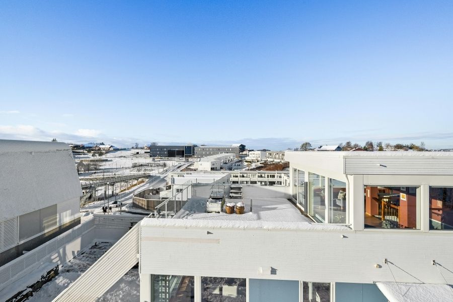 A view of a roof top with a white roof and white windows